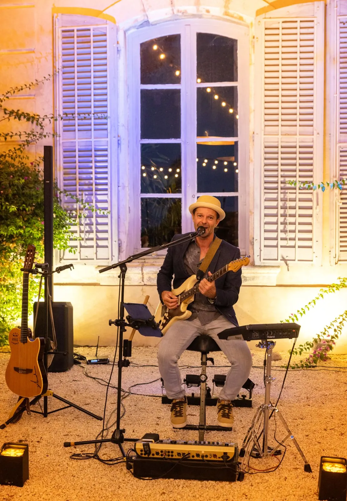 Concert acoustique devant une bastide, sous les guirlandes