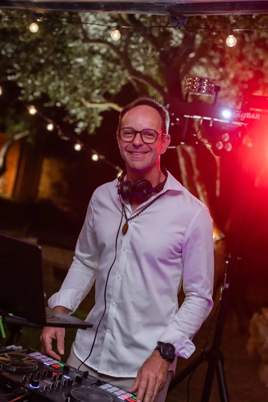 Cédric B., DJ, à ses platines sous les guirlandes pendant une soirée