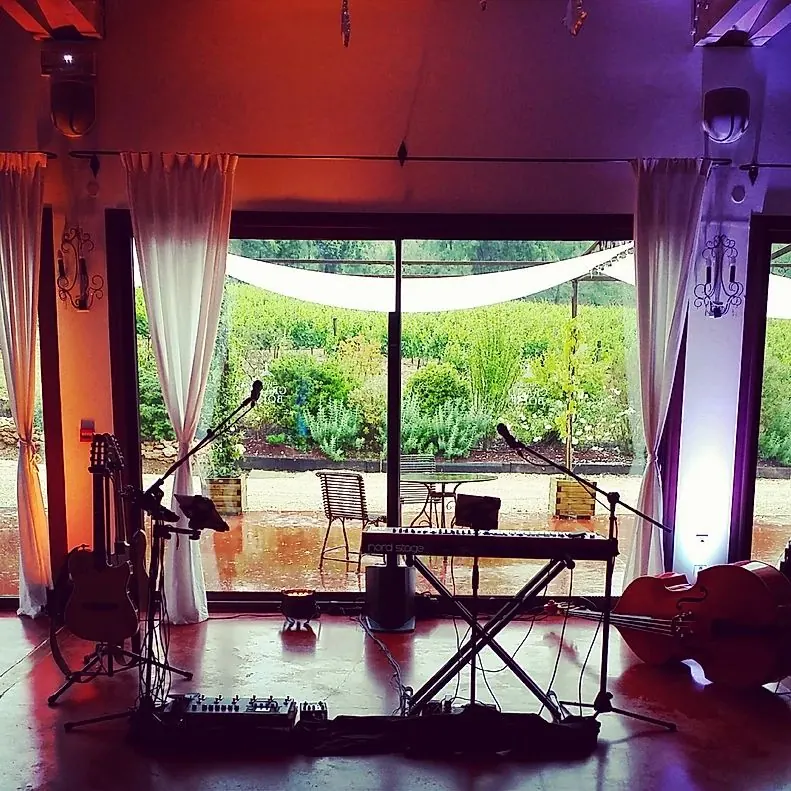Salle de réception avec scène et clavier, ouverte sur le jardin